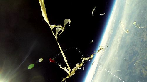 Geplatzte Ballonhülle vor dem schwarzen Himmel und der Erdkrümmung